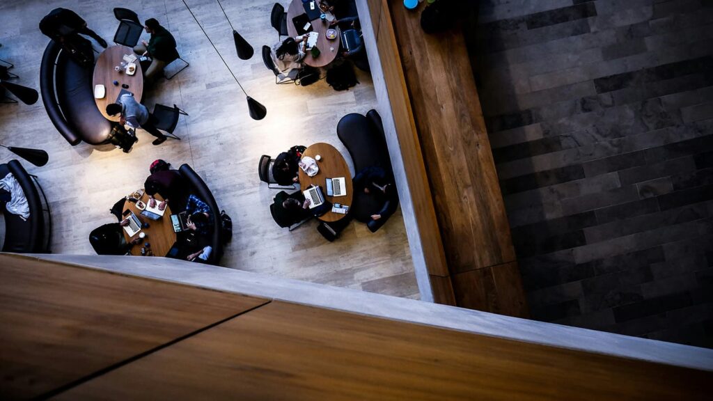 people sitting at tables in an office setting